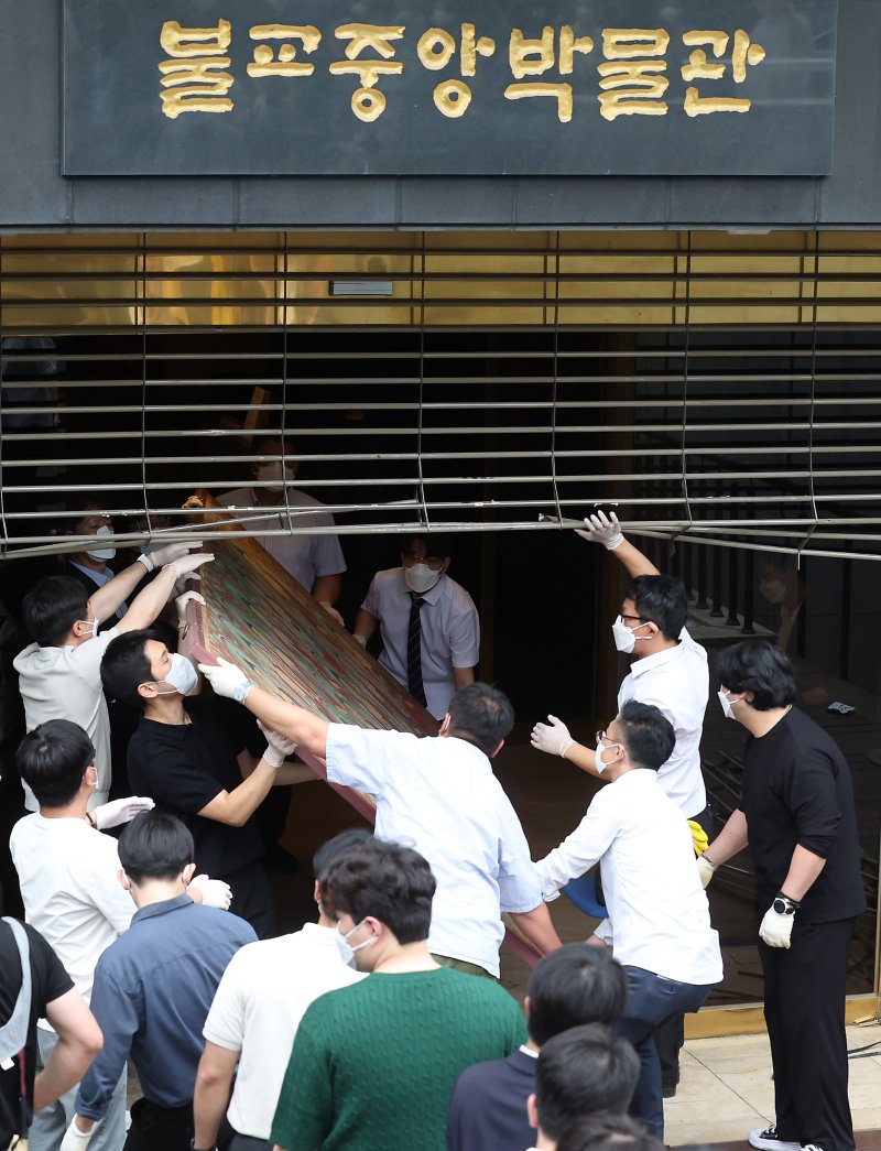 [서울=뉴시스] 김명년 기자 = 10일 오전 서울 종로구 조계사 옆 한국불교역사문화기념관 국제회의장에서 화재가 발생해 관계자들이 문화재를 옮기고 있다. 2025.06.09. kmn@newsis.com