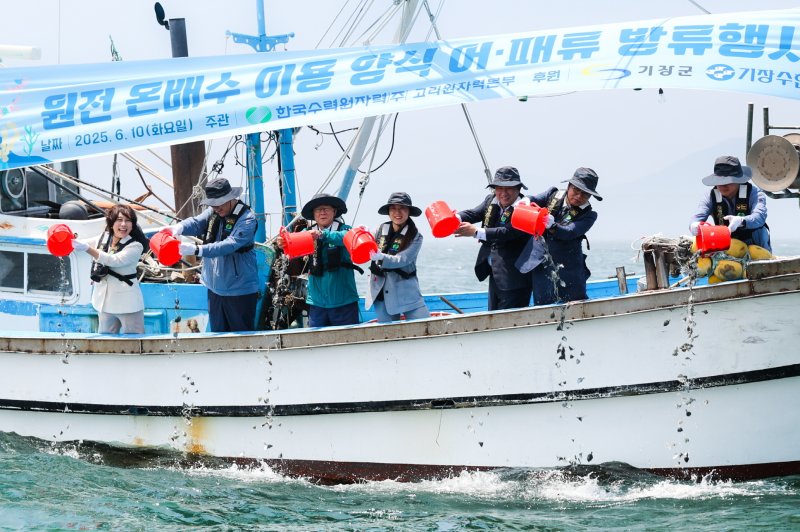 부산 기장군 장안읍 월내항에서 진행된 '온배수 양식 어패류 방류행사'에서 참석자들이 어패류를 바다에 방류하고 있다.(고리원자력본부 제공. 재판매 및 DB 금지)