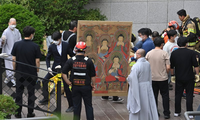 [서울=뉴시스] 김명년 기자 = 10일 오전 서울 종로구 조계사 옆 한국불교역사문화기념관 국제회의장에서 화재가 발생해 관계자들이 문화재를 옮기고 있다. 2025.06.09. kmn@newsis.com