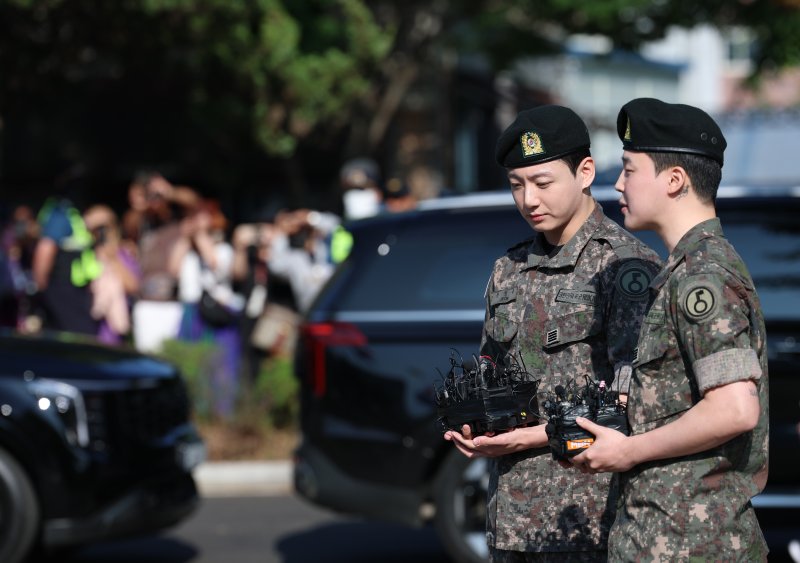방탄소년단(BTS)의 정국과 지민(오른쪽)이 11일 오전 경기도 연천군 연천공설운동장에서 군복무를 마친 뒤 전역 인사를 전하고 있다. ⓒ News1 권현진 기자
