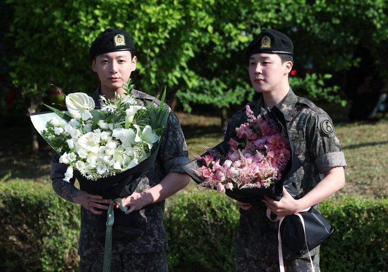 방탄소년단(BTS)의 정국과 지민(오른쪽)이 11일 오전 경기도 연천군 연천공설운동장에서 군 복무를 마친 뒤 전역 인사를 하고 있다. ⓒ News1 권현진 기자