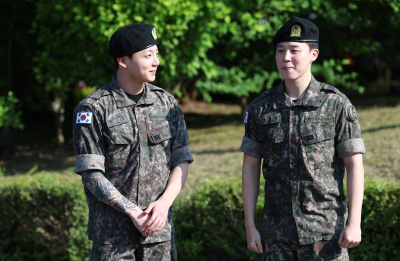 방탄소년단(BTS)의 정국과 지민(오른쪽)이 11일 오전 경기도 연천군 연천공설운동장에서 군 복무를 마친 뒤 군복무를 마친 뒤 수줍은 미소를 짓고 있다. ⓒ News1 권현진 기자