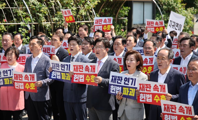 [서울=뉴시스] 김금보 기자 = 김용태 국민의힘 비상대책위원장과 권성동 원내대표 등 참석 의원들이 11일 오전 서울 서초구 서울고등법원에서 법원의 이재명 대통령 공직선거법 위반 파기환송심 기일 추후 지정 결정을 비판하는 현장의원총회를 열고 구호를 외치고 있다. 2025.06.11. kgb@newsis.com