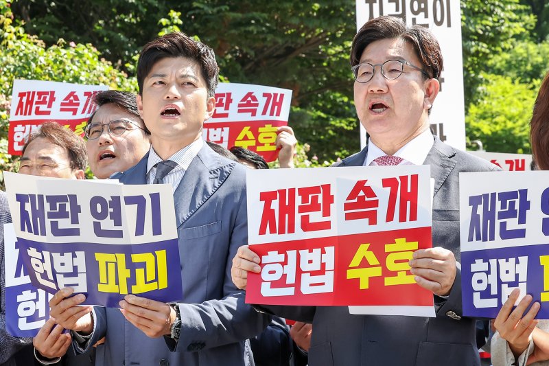 김용태 국민의힘 비상대책위원장(왼쪽)과 권성동 원내대표가 11일 오전 서울 서초구 서울중앙지방법원 앞에서 열린 '헌법 파괴 저지를 위한 현장 의원총회'에서 정부·여당을 향한 규탄 구호를 외치고 있다. 2025.6.11/뉴스1 ⓒ News1 민경석 기자