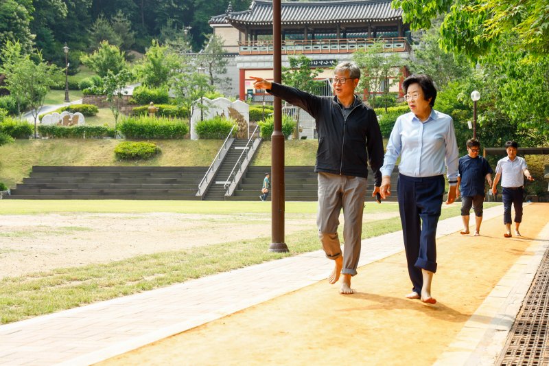 [이천=뉴시스] 김경희 이천시장(사진 오른쪽)이 서희테마파크에 조성한 황톳길을 걷고 있다 (사진=이천시 제공) 2025.06.11.photo@newsis.com