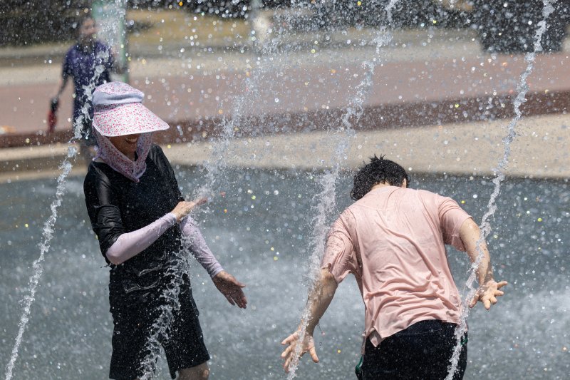 서울 낮 최고기온이 29도로 예보된 11일 서울 여의도 한강공원 물빛광장 분수대를 찾은 시민들이 더위를 식히고 있다. 2025.6.11/뉴스1 ⓒ News1 이승배 기자