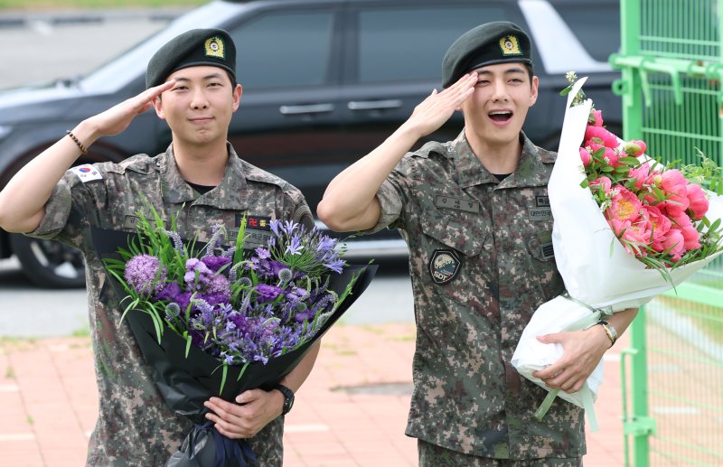 방탄소년단(BTS)의 RM(김남준, 30)과 뷔(김태형, 29)가 10일 오전 강원도 춘천시 신북읍 체육공원 축구장에서 군 복무를 마친 뒤 전역 인사를 하고 있다. ⓒ News1 권현진 기자