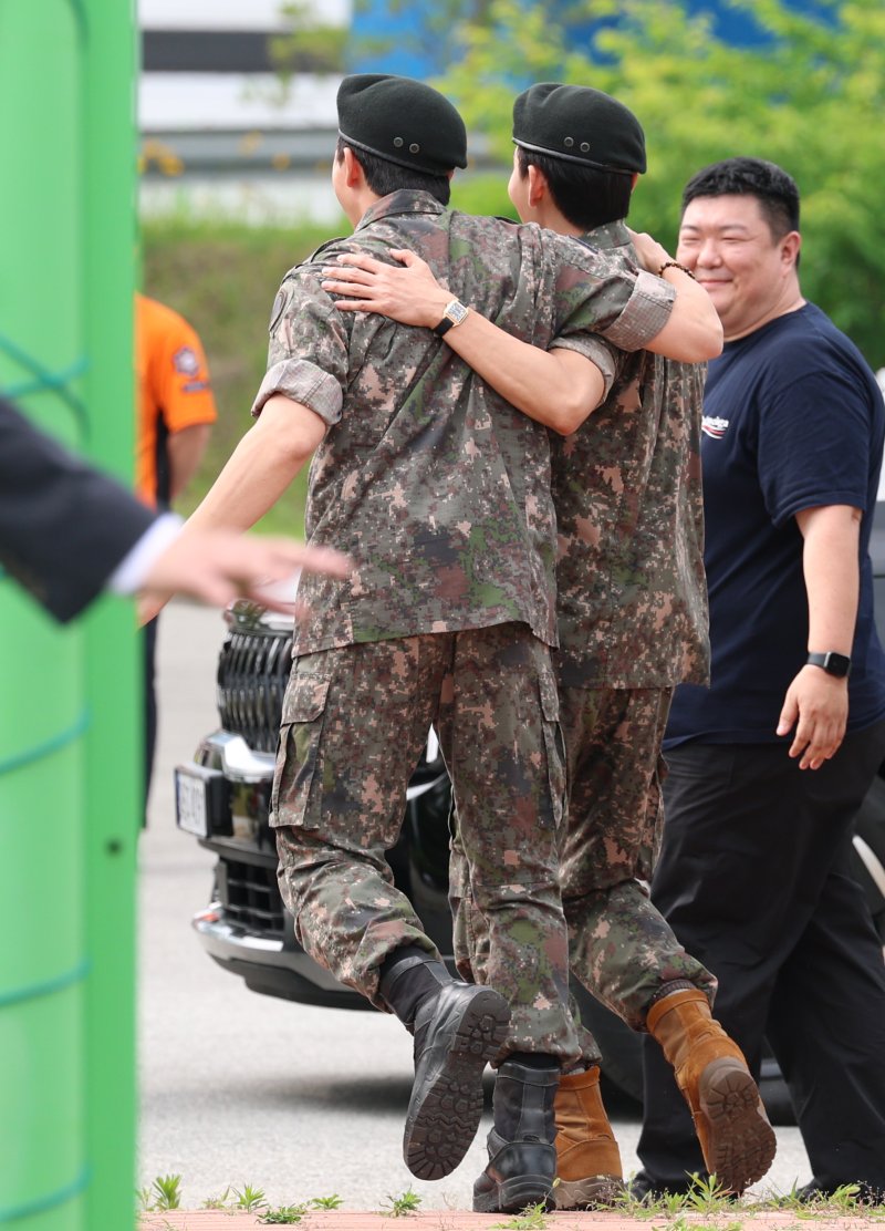 방탄소년단(BTS)의 RM(김남준, 30)과 뷔(김태형, 29)가 10일 오전 강원도 춘천시 신북읍 체육공원 축구장에서 전역 인사를 마친 뒤 어깨 동무를 하고 준비된 차량으로 이동하고 있다. ⓒ News1 권현진 기자
