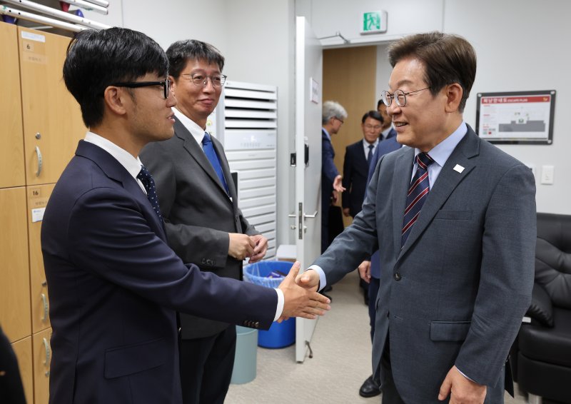 [서울=뉴시스] 최진석 기자 = 이재명 대통령이 12일 서울 용산 대통령실 사진기자실을 방문해 사진기자와 악수하고 있다. 2025.06.12. myjs@newsis.com