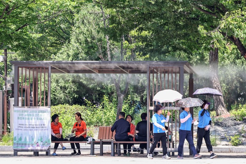 서울 지역 낮 최고바카라사이트 홍보 승리바카라이 31도까지 올라 초여름 더위가 찾아온 12일 서울 영등포구 여의도공원에서 시민들이 쿨링포그 아래에 앉아 무더위를 쫓고 있다. 2025.6.12/바카라사이트 홍보 승리바카라1 ⓒ News1 민경석 기자