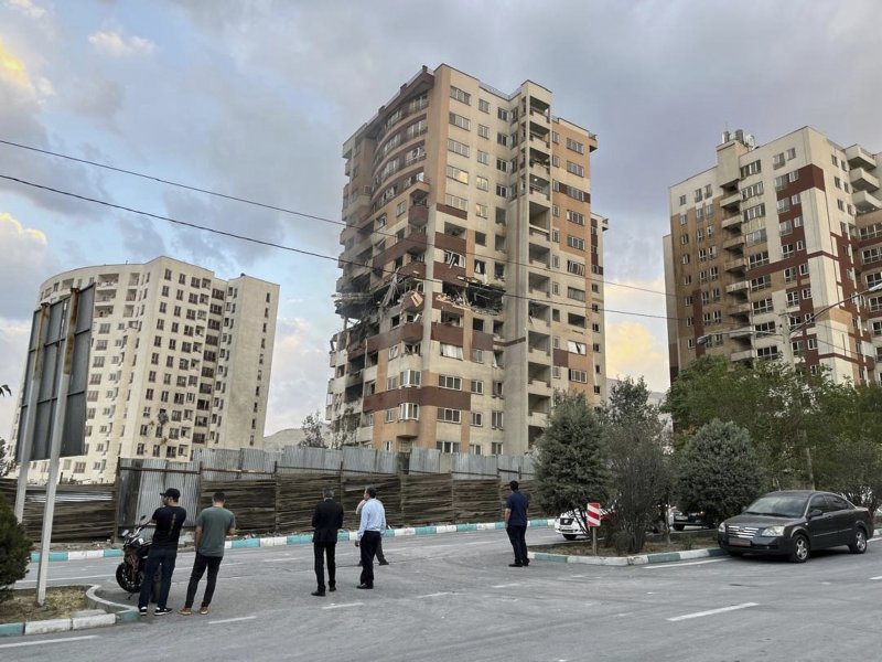 [테헤란=AP/뉴시스] 13일(현지 시간) 이란 테헤란에서 주민들이 이스라엘의 공습으로 파손된 아파트 건물을 지켜보고 있다. 이스라엘방위군(IDF)은 이날 새벽 이스라엘이 이란의 핵·군 시설에 대한 선제타격을 개시했다고 성명을 통해 밝혔다. 2025.06.13.