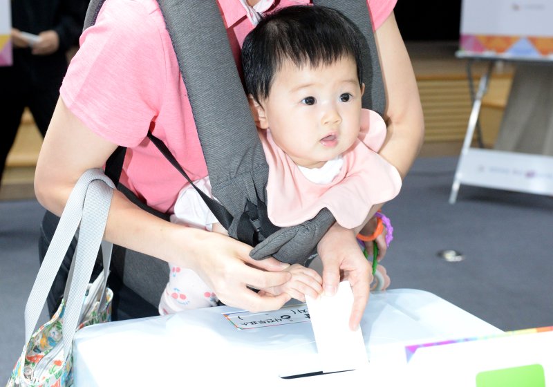 [울산=뉴시스] 배병수 기자 = 사진은 제21대 대통령선거 사전투표가 시작됐던 지난달 29일 울산 남구 남구청 6층 삼산동 사전투표소에서 한 유권자가 어린안전한 바카라사이트 산타카지노와 함께 투표를 하고 있는 모습. 2025.05.29.bbs@newsis.com.