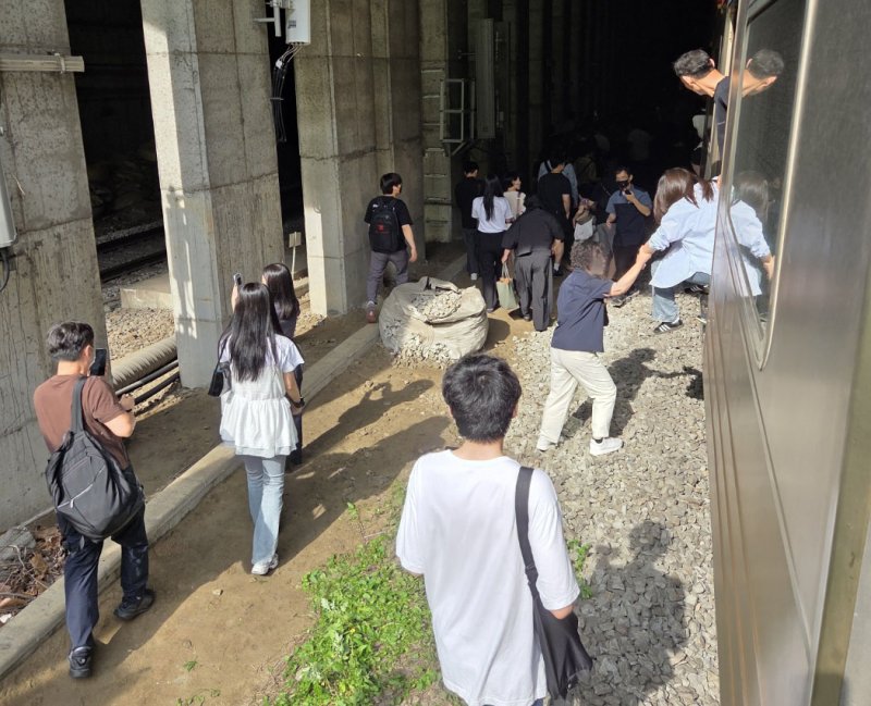 13일 오전 경의중앙선 신촌역 인근에서 서울역행 경의중앙선 열차가 단전으로 인해 신촌역 앞 50m지점에서 멈취 승객들이 열차에서 내려 신촌 역으로 걸어가고 있다. (독자 제공, 재판매 및 DB금지) 2025.6.13/뉴스1