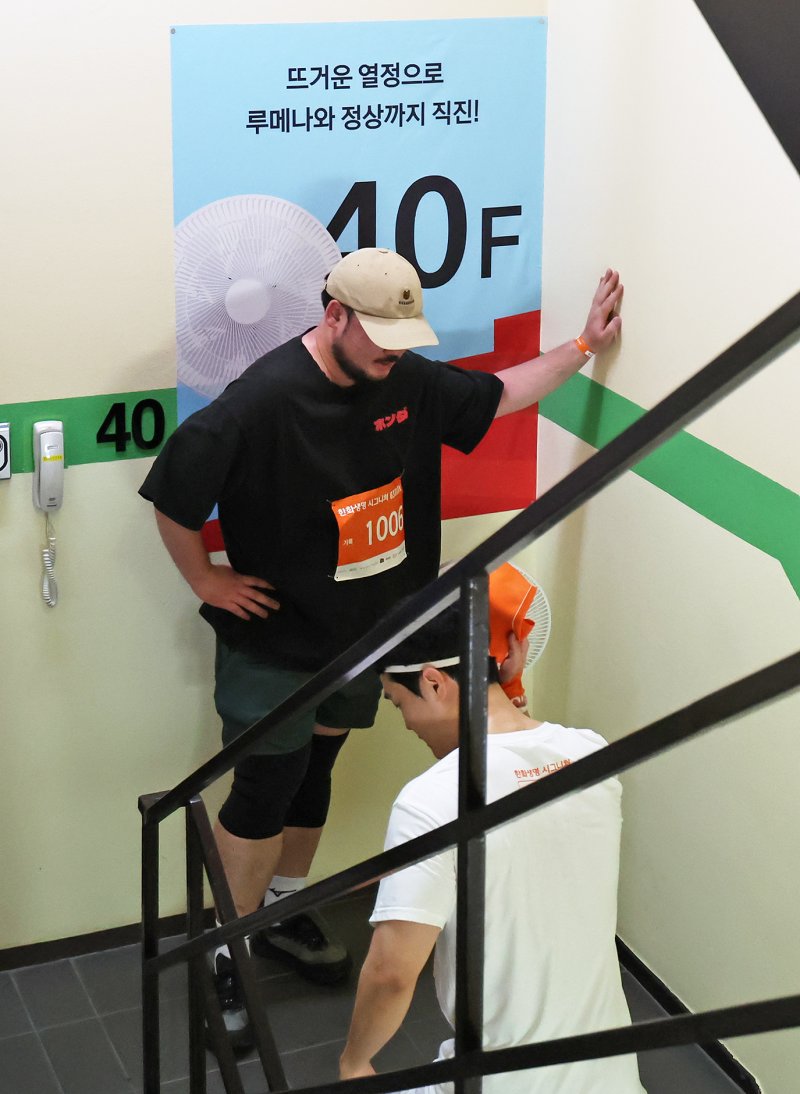 14일 오전 서울 여의도 63빌딩에서 열린 '한화생명 시그니처 63 RUN'에서 참가자가 60층을 향해 계단을 오르던 중 휴식을 취하고 있다. 2025.6.14/뉴스1 ⓒ News1 장수영 기자