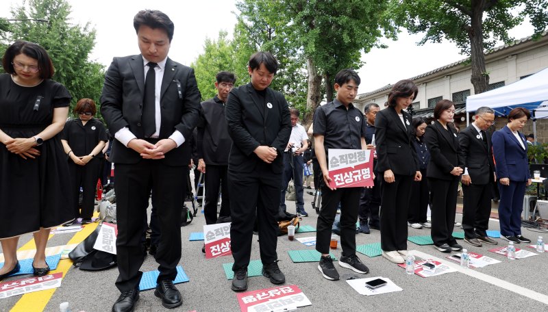 [서울=뉴시스] 추상철 기자 = 14일 오후 서울 종로구 정부서울청사 인근에서 열린 전교조, 교총, 교사노조 등 교원 3단체의 '제주 교사 추모 및 교권 보호 대책 요구' 집회에서 참가자들이 묵념을 하고 있다. 2025.06.14. scchoo@newsis.com