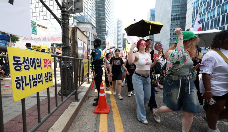 [서울=뉴시스] 김선웅 기자 = 14일 서울 중구 을지로 일대에서 열린 제26회 서울퀴어문화축제 참가자들이 퀴어퍼레이드를 하는 옆으로 기독교 단체 회원들이 반대 집회를 하고 있다. 2025.06.14. mangusta@newsis.com