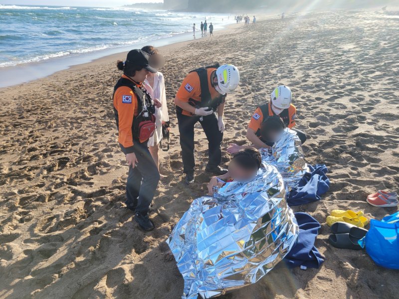 14일 오후 제주 중문해수욕장에서 구조된 10대 2명이 소방대원들의 처치를 받고 있다.(제주소방안전본부 제공. 재판매 및 DB 금지)