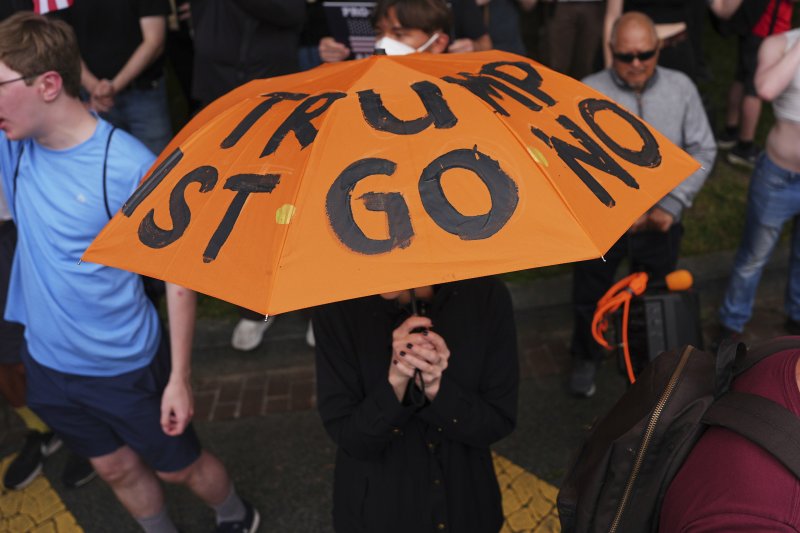 [워싱턴=AP/뉴시스] 미국 워싱턴에서 육군 창설 250주년 기념 대규모 열병식이 열린 가운데 일부 시위 참가자들이 트럼프 반대 문구가 새겨진 우산을 들고 나왔다. 2025.06.15.