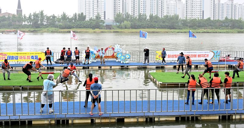 2025 태화강 마두희 축제 '수상 줄다리기'에 참가한 외국인 방문객들이 물에 빠지지 않으려고 아슬아슬한 승부를 펼치고 있다. 울산 중구 제공