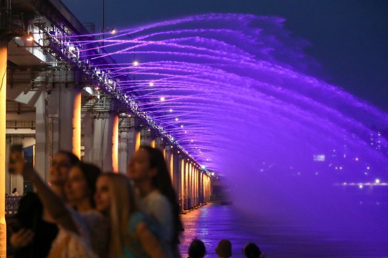 서울 지역 낮 최고기온이 33도를 넘어서는 등 전국적으로 무더위가 나타난 26일 오후 서울 서초구 반포한강공원에서 외국인 관광객들과 시민들이 반포대교 달빛무지개분수를 감상하며 열대야를 이겨내고 있다. 2022.7.26/뉴스1 ⓒ News1 민경석 기자