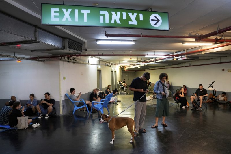 [텔아비브=AP/뉴시스] 15일(현지 시간) 이스라엘 텔아비브에서 이란의 미사일 발사로 공습경보가 울리자 시민들이 대피소에 대피하고 있다. 2025.06.15.