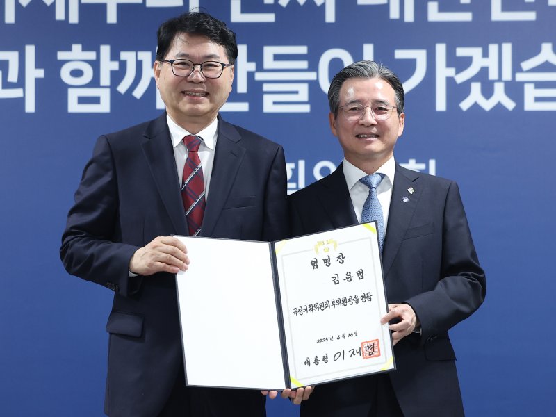 [서울=뉴시스] 김진아 기자 = 이한주(왼쪽) 국정기획위원회 위원장이 16일 서울 종로구 정부서울청사 창성동 별관에서 열린 출범식에서 부위원장을 맡은 김용범 대통령실 정책실장에게 위촉장을 수여한 뒤 기념 촬영을 하고 있다. 이재명 정부의 대통령직인수위원회 역할을 하는 국정기획위에서는 100대 국정과제를 정리하고 과제별로 추진 시점과 목표 등을 정해 '국정운영 5개년 계획'을 마련할 방침이다. (공동취재) 2025.06.16. photo@newsis.com