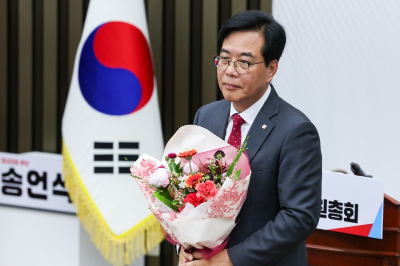 국민의힘 신임 원내대표로 선출된 송언석 의원이 16일 오후 서울 여의도 국회에서 열린 의원총회에서 꽃다발을 들고 있다. 2025.6.16/뉴스1 ⓒ News1 안은나 기자