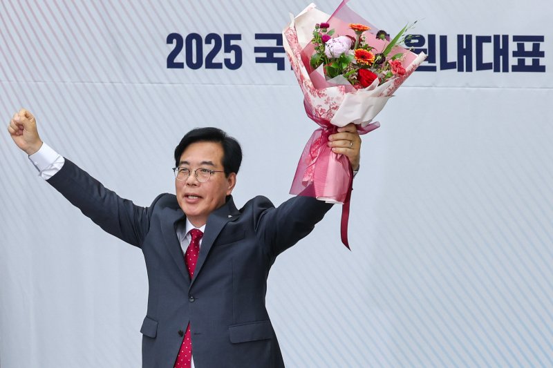 국민의힘 신임 원내대표로 선출된 송언석 의원이 16일 오후 서울 여의도 국회에서 열린 의원총회에서 꽃다발을 들어보이고 있다. 2025.6.16/뉴스1 ⓒ News1 안은나 기자