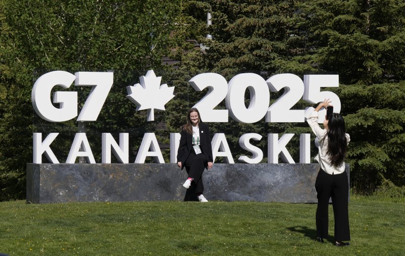 15일(현지시간) 캐나다 앨버타주 캐내내스키스에서 열리는 주요7개국(G7) 정상회의의 미디어 센터가 위치한 인근 밴프에서 두 여성이 행사 간판 앞에서 기념촬영을 하고 있다. AP연합뉴스