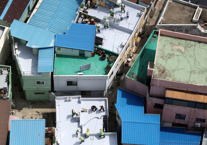[부산=뉴시스] 하경민 기자 = 부산시자원봉사센터와 7개 기업·기관, 대학생 자원봉사자 등 130여 명이 17일 부산 남구 문현2동 일대 주택 20여 곳의 옥상에서 쿨루프(Cool Roof) 열차단 페인트를 도포하는 봉사활동을 하고 있다.쿨루프는 태양열 반사 및 열 차단 효과가 있는 친환경 도료를 주택 지붕 및 옥상에 도포해 실내온도를 효과적으로 낮추는 기술이다. 2025.06.17. yulnetphoto@newsis.com