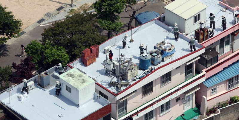 [부산=뉴시스] 하경민 기자 = 부산시자원봉사센터와 7개 기업·기관, 대학생 자원봉사자 등 130여 명이 17일 부산 남구 문현2동 일대 주택 20여 곳의 옥상에서 쿨루프(Cool Roof) 열차단 페인트를 도포하는 봉사활동을 하고 있다.쿨루프는 태양열 반사 및 열 차단 효과가 있는 친환경 도료를 주택 지붕 및 옥상에 도포해 실내온도를 효과적으로 낮추는 기술이다. 2025.06.17. yulnetphoto@newsis.com