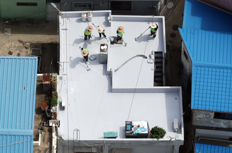 [부산=뉴시스] 하경민 기자 = 부산시자원봉사센터와 7개 기업·기관, 대학생 자원봉사자 등 130여 명이 17일 부산 남구 문현2동 일대 주택 20여 곳의 옥상에서 쿨루프(Cool Roof) 열차단 페인트를 도포하는 봉사활동을 하고 있다. 쿨루프는 태양열 반사 및 열 차단 효과가 있는 친환경 도료를 주택 지붕 및 옥상에 도포해 실내온도를 효과적으로 낮추는 기술이다. 2025.06.17. yulnetphoto@newsis.com
