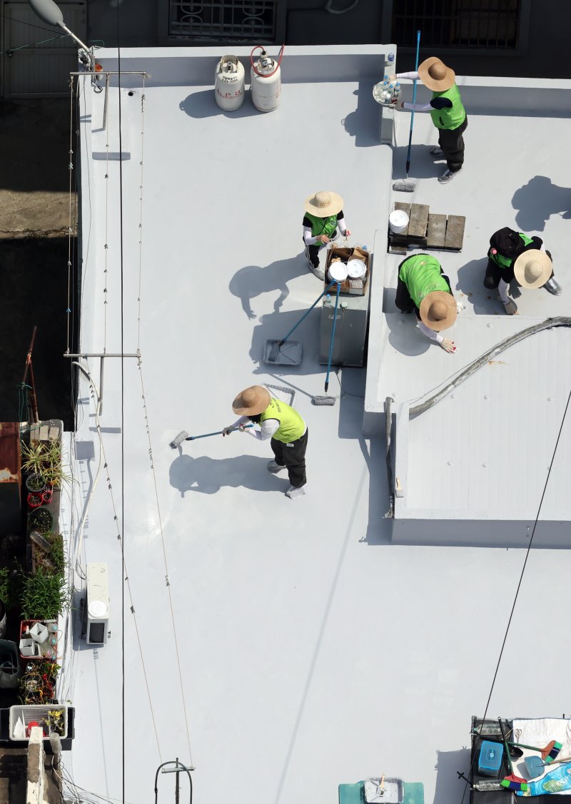 [부산=뉴시스] 하경민 기자 = 부산시자원봉사센터와 7개 기업·기관, 대학생 자원봉사자 등 130여 명이 17일 부산 남구 문현2동 일대 주택 20여 곳의 옥상에서 쿨루프(Cool Roof) 열차단 페인트를 도포하는 봉사활동을 하고 있다.쿨루프는 태양열 반사 및 열 차단 효과가 있는 친환경 도료를 주택 지붕 및 옥상에 도포해 실내온도를 효과적으로 낮추는 기술이다. 2025.06.17. yulnetphoto@newsis.com