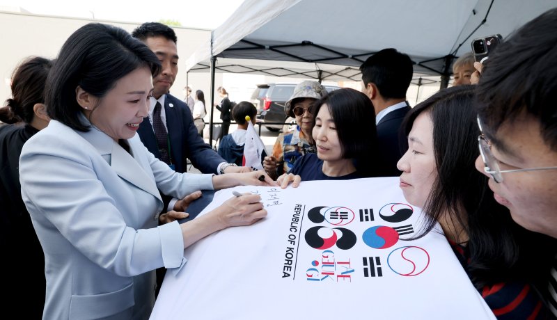 [캘거리=뉴시스] 최진석 기자 = 이재명 대통령 부인 김혜경 여사가 17일(현지 시간) 캐나다 앨버타주 캘거리 한인회관에서 열린 캐나다 서부 동포사회와의 대화를 나누기 전 인사하며 티셔츠에 싸인을 하고 있다. 2025.06.18. myjs@newsis.com