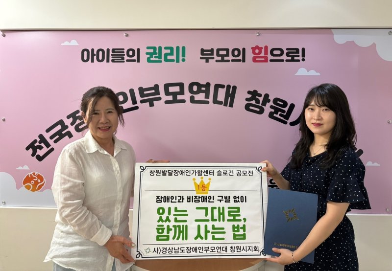 [창원=뉴시스] 경상남도장애인부모연대 배선이(왼쪽) 창원시지회장이 창원발달장애인가활센터 슬로건 공모전 당선작 문구와 상장을 김가현씨에게 전달하고 있다. (사진=경상남도장애인부모연대 창원시지회 제공) 2025.06.18. photo@newsis.com