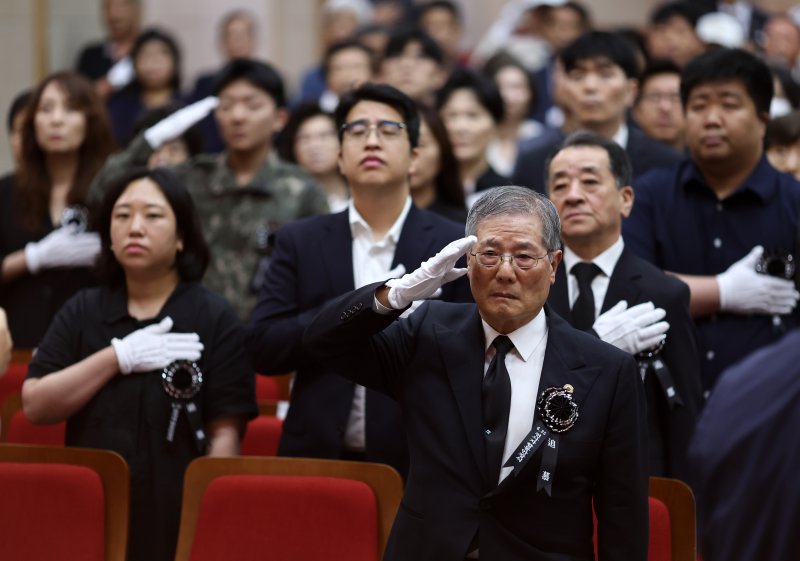 지난 6월 18일 국립서울현충원에서 열린 6·25 전사자 발굴유해 합동 안장식에 유가족들이 국기에 대한 경례를 하고 있다. 연합뉴스