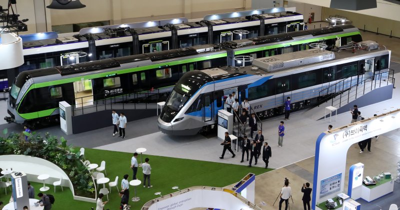 18일 부산 해운대구 벡스코 제1전시장에서 열린 '2025 부산국제철도기술산업전'에서 관람객들이 현대로템의 공항철도 전동차, 대만 그린라인 무인전동차, 캐나다 에드먼턴 밸리라인 웨스트 트램 실물을 둘러보고 있다. 2025.6.18/뉴스1 ⓒ News1 윤일지 기자