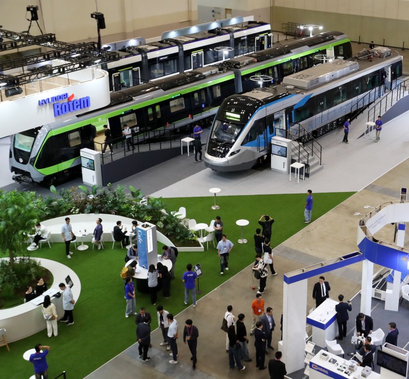 18일 부산 해운대구 벡스코 제1전시장에서 열린 '2025 부산국제철도기술산업전'에서 관람객들이 현대로템의 공항철도 전동차, 대만 그린라인 무인전동차, 캐나다 에드먼턴 밸리라인 웨스트 트램 실물을 둘러보고 있다. 2025.6.18/뉴스1 ⓒ News1 윤일지 기자