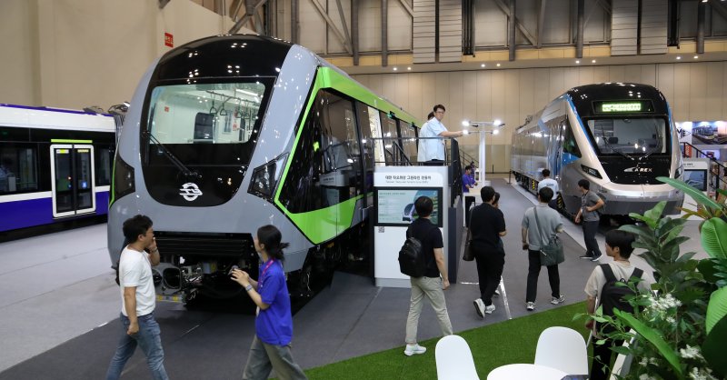 18일 부산 해운대구 벡스코 제1전시장에서 열린 '2025 부산국제철도기술산업전'에서 관람객들이 현대로템의 공항철도 전동차, 대만 그린라인 무인전동차, 캐나다 에드먼턴 밸리라인 웨스트 트램 실물을 둘러보고 있다. 2025.6.18/뉴스1 ⓒ News1 윤일지 기자