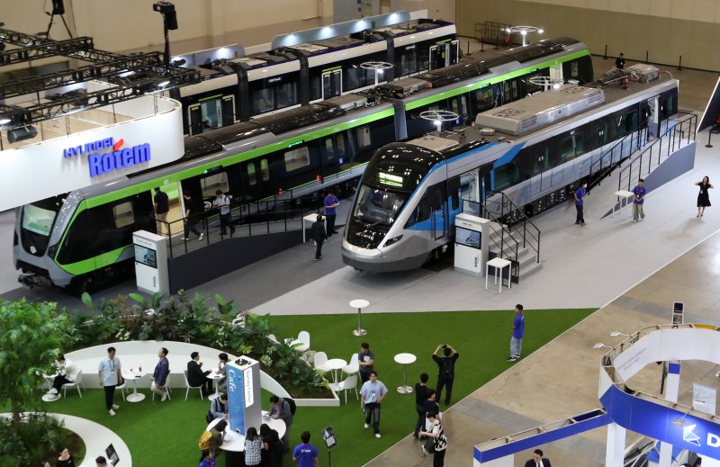 18일 부산 해운대구 벡스코 제1전시장에서 열린 '2025 부산국제철도기술산업전'에서 관람객들이 현대로템의 공항철도 전동차, 대만 그린라인 무인전동차, 캐나다 에드먼턴 밸리라인 웨스트 트램 실물을 둘러보고 있다. 2025.6.18/뉴스1 ⓒ News1 윤일지 기자