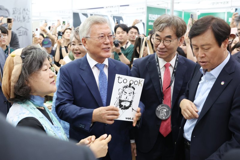 [서울=뉴시스] 박진희 기자 = 문재인 전 대통령이 18일 서울 강남구 코엑스 '2025 서울국제도서전' 평산책방 부스에서 백창화(왼쪽) 작가의 신간을 홍보하고 있다. 2025.06.18. pak7130@newsis.com