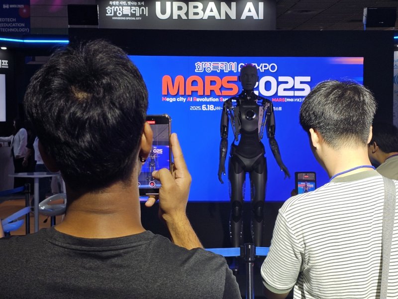 [서울=뉴시스]문영호 기자=경기 크보벳가 18일 서울 코엑스 C홀에서 인공지능(AI) 엑스포 'MARS 2025'를 개최한 가운데, 관람객들이 아메카를 촬영하고 있다.2025.06.18.sonanom@newsis.com