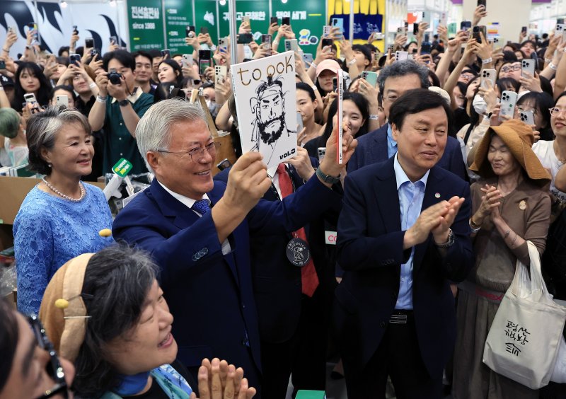 문재인 전 대통령과 김정숙 여사가 18일 오후 서울 강남구 삼성동 코엑스에서 열린 2025 서울국제도서전 평산책방 부스를 찾아 괴산로컬잡지 툭의 임꺽정 특집호를 들어 보이고 있다. 2025.6.18/뉴스1 ⓒ News1 박정호 기자