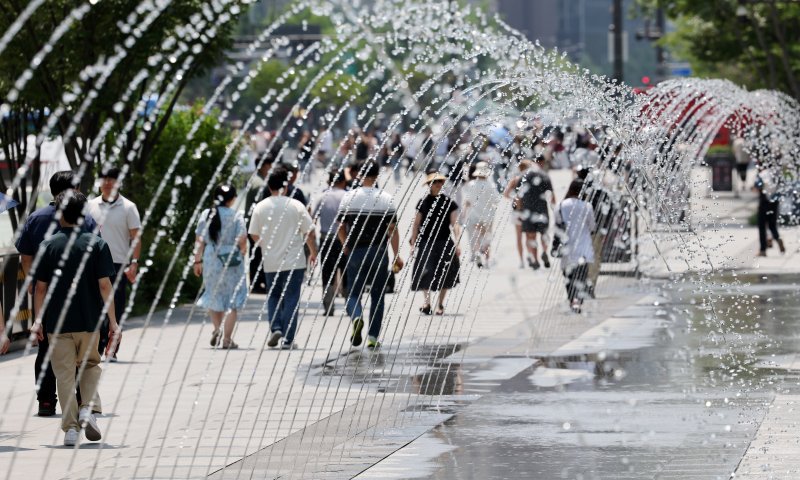 [서울=뉴시스] 배훈식 기자 = 서울 낮 최고기온 31도 등 전국이 30도 안팎의 무더운 바카라사이트 신고를 보인 18일 오후 서울 종로구 광화문광장에서 더위를 식혀주는 바닥분수 물줄기 사이로 시민들이 발걸음을 옮기고 있다. 2025.06.18. dahora83@newsis.com