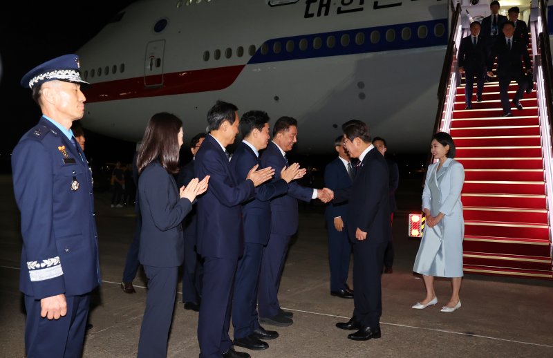 [성남=뉴시스] 최진석 기자 = 이재명 대통령과 부인 김혜경 여사가 19일 주요 7개국(G7) 정상회의 참석을 마치고 성남 서울공항에 도착해 공군 1호기 내려 김병기 더불어민주당 당대표 직무대행 겸 원내대표와 악수하고 있다. 2025.06.19. myjs@newsis.com