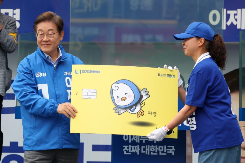 [파주=뉴시스] 조성우 기자 = 이재명 대통령이 지난달 20일 경기 파주시 금릉역 중앙광장에서 열린 유세에서 선거운동원으로부터 경기지역화폐 파주페이 모형을 받고 있다. 2025.05.20. xconfind@newsis.com