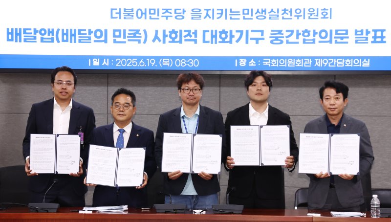 더불어민주당 을지로위원회 민병덕 위원장과 김범석 우아한형제들 대표, 김진우 전국가맹점주협의회 의장 등 참석자들이 19일 오전 서울 여의도 국회에서 배달앱(배달의민족) 사회적대화기구 중간합의문 발표 브리핑에서 중간합의문에 서명한 뒤 기념촬영을 하고 있다. 2025.6.19/뉴스1 ⓒ News1 김민지 기자