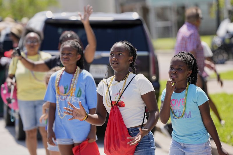 [갤버스턴=AP/뉴시스] 19일(현지 시간) 미 텍사스주 갤버스턴에서 '준틴스' 퍼레이드를 지켜보는 소녀들이 행렬에서 던져주는 사탕을 기다리고 있다. '준틴스'는 1865년 6월 19일 텍사스주를 끝으로 흑인 노예제가 폐지된 것을 기념하는 연방 공휴일이다. 2025.06.20.