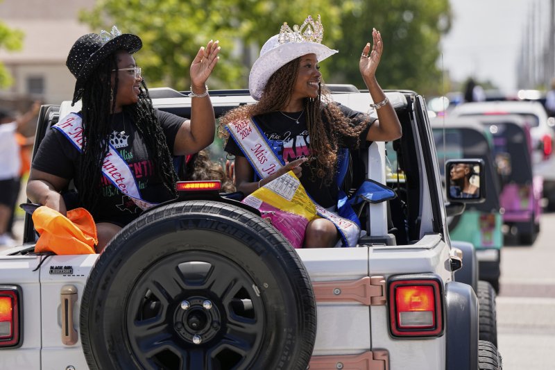 [갤버스턴=AP/뉴시스] 19일(현지 시간) 미 텍사스주 갤버스턴에서 열린 '준틴스' 기념행사에서 참가자들이 손을 흔들고 있다. '준틴스'는 1865년 6월 19일 텍사스주를 끝으로 흑인 노예제가 폐지된 것을 기념하는 연방 공휴일이다. 2025.06.20.