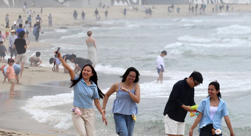 부산 해운대해수욕장이 개장한 후 첫 주말을 맞은 22일 해운대해수욕장을 찾은 외국인 관광객들이 해변을 거닐며 활짝 웃고 있다. 2025.6.22/뉴스1 ⓒ News1 윤일지 기자